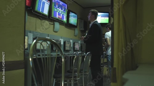 Man in suite bets on sports betting after hard work day