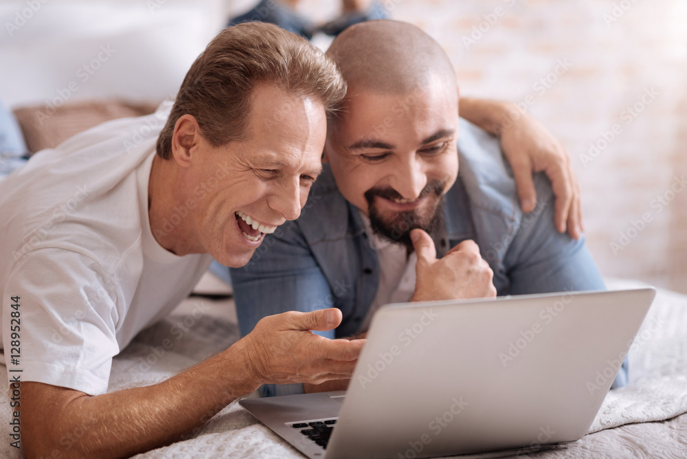 Joyful friends watching videos at home Joyful friends watching videos at home