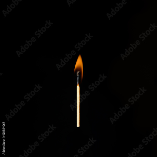 one burning match on a black background