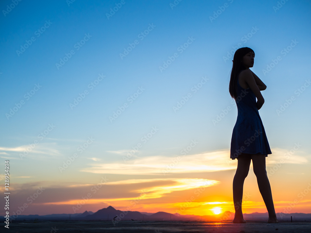 Silhouette of free woman enjoying freedom feeling happy at sunset. relaxing woman in pure happiness