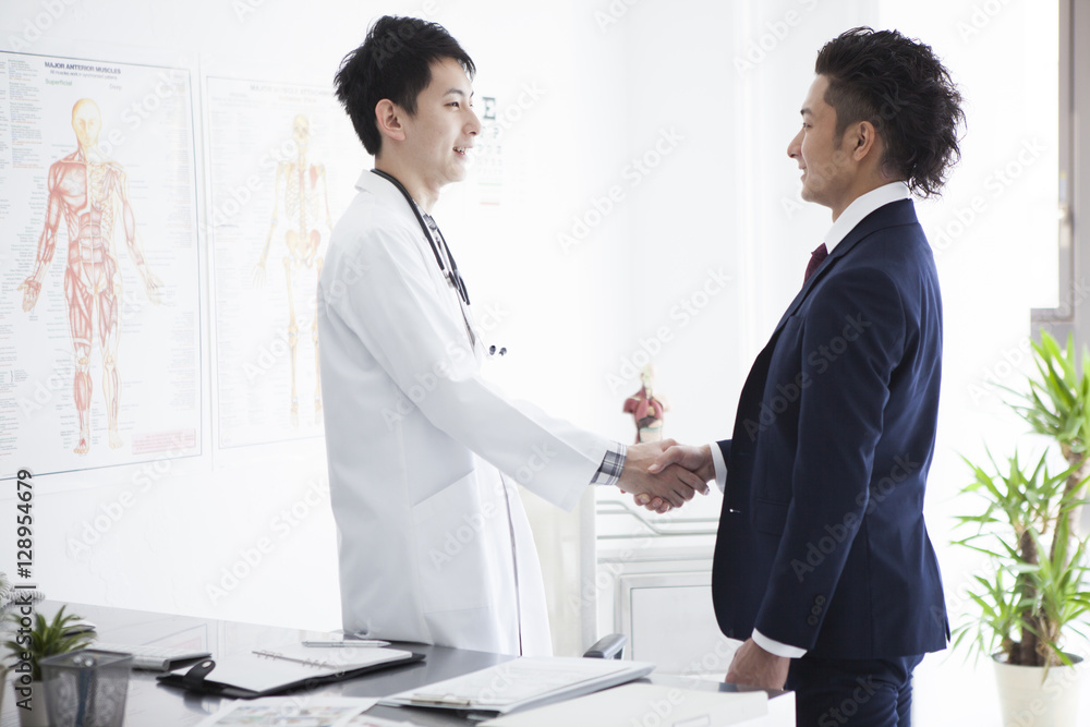 Doctor and salesman of pharmaceutical company are shaking hands