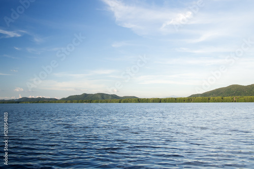Landscape view with deep blue sky. Light from the right. Contrast on water wave.