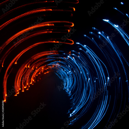 Colorful abstract trails of light. Dots, lines and bokeh on dark background. Long exposure.