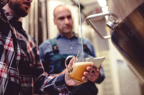 Photography Owner pouring beer in glass at brewery