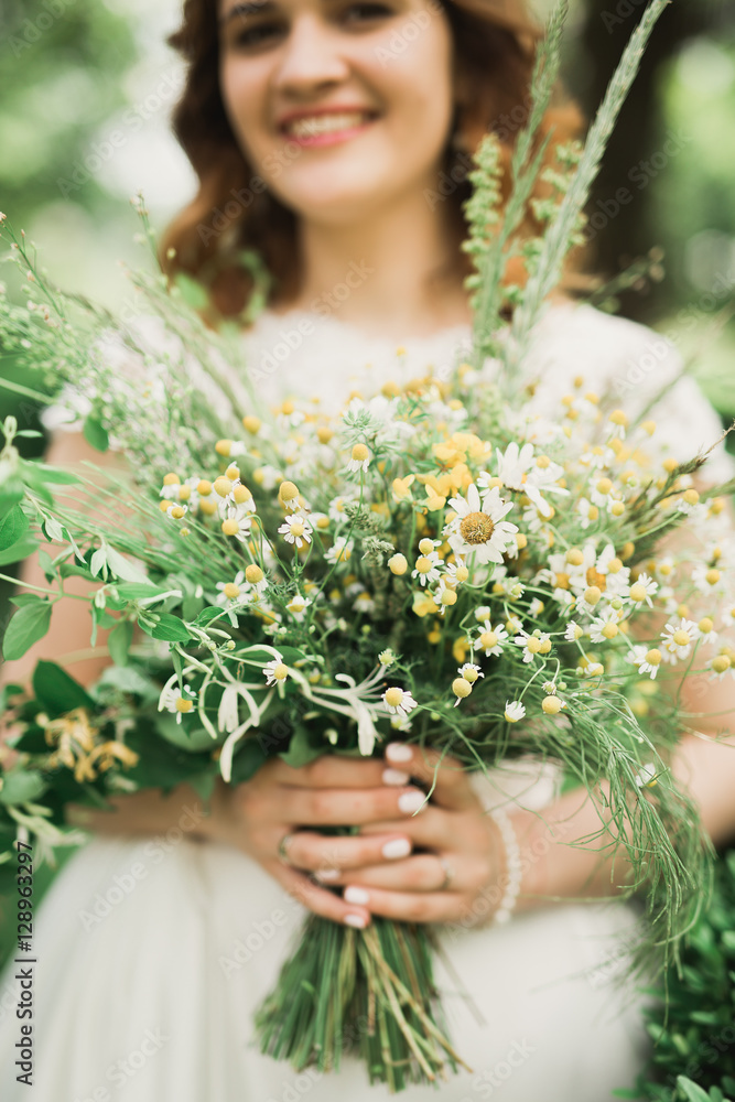 The bride holding bouquet of flowers in park. Wedding The bride holding bouquet of flowers in park. Wedding