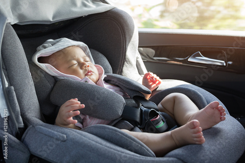 Close Up Asian cute newborn baby sleeping in modern car seat.