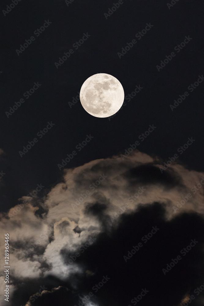 Supermoon with night sky and clouds.