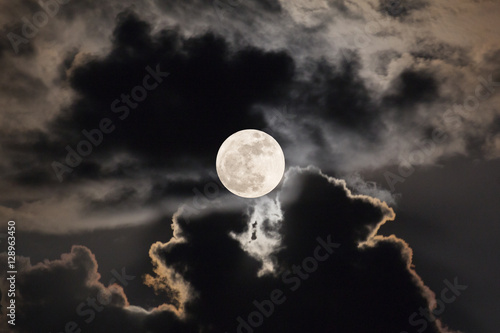 Supermoon with night sky and clouds.