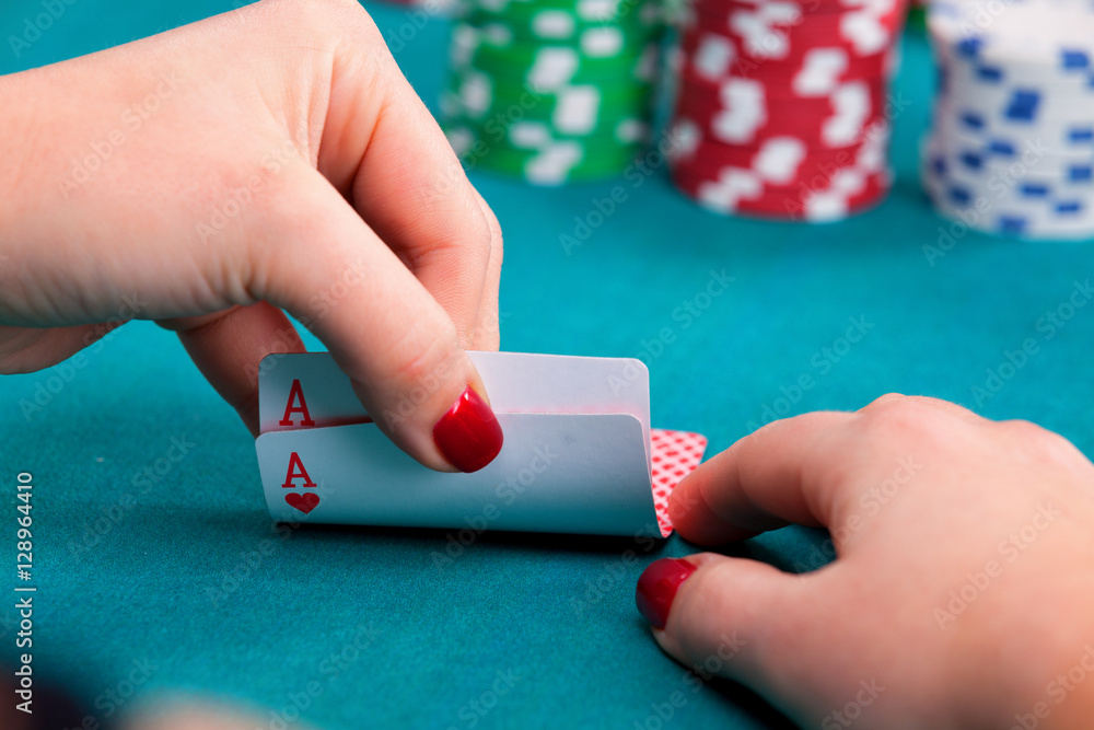 Young woman holding pocket aces poker cards in front of gambling Young woman holding pocket aces poker cards in front of gambling