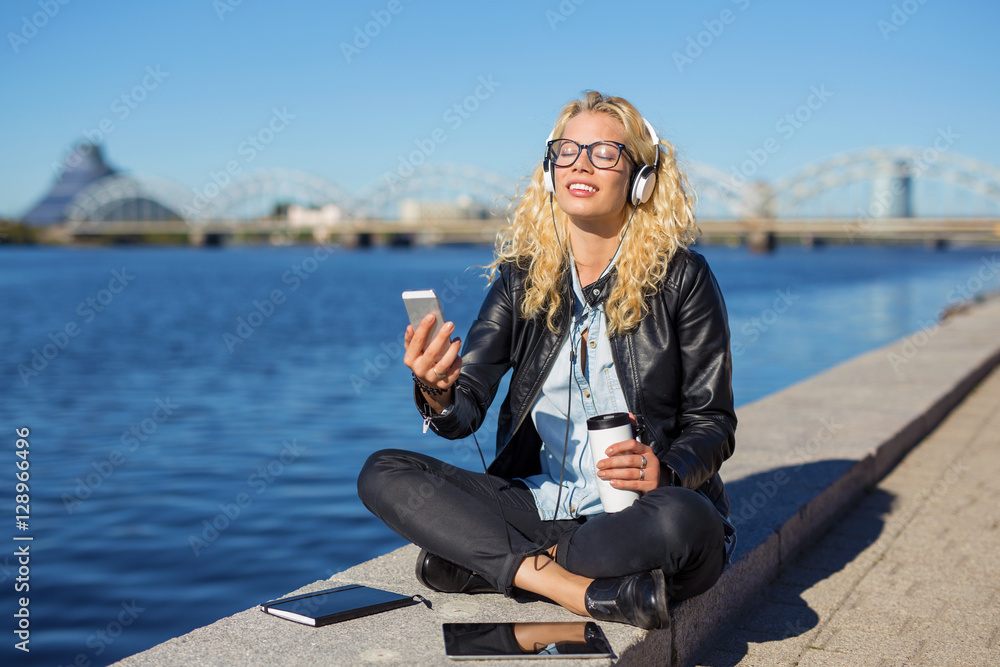 Woman ejoying the music in her headphones from smartphone