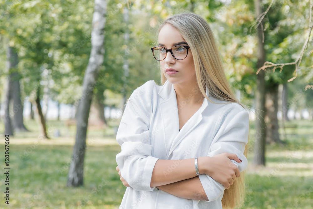 a young woman doctor, blonde in glasses in park outdoors a young woman doctor, blonde in glasses in park outdoors