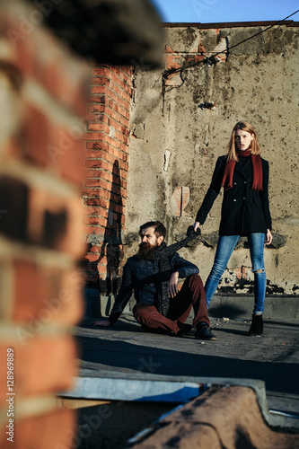 Young couple near roof brick wall