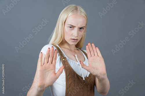 Closeup portrait of scared school girl raising hands up in defen photo