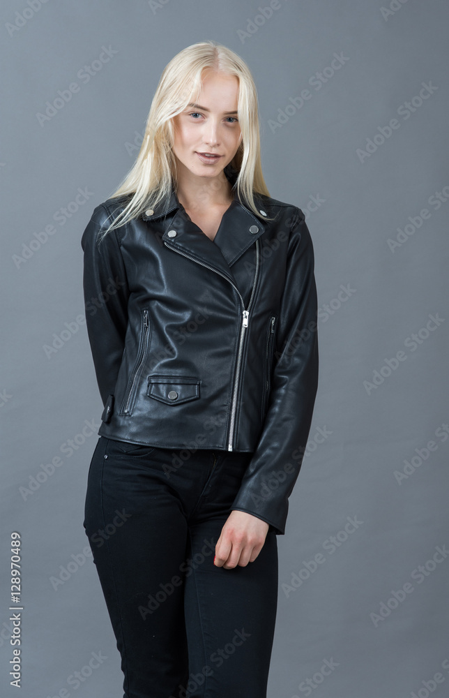 Portrait of a blond girl in a leather jacket gray studio backgro Portrait of a blond girl in a leather jacket gray studio backgro