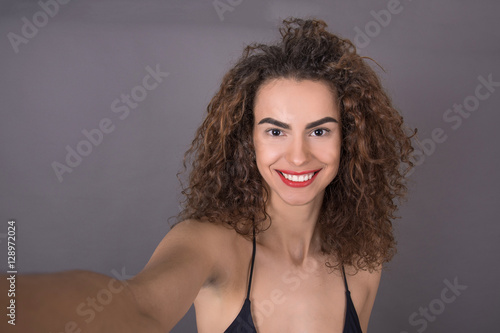 beautiful curly girl takes selfie