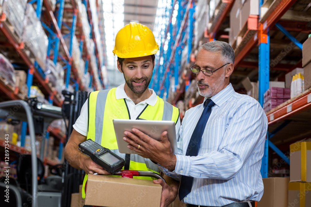 Manager with interacting worker over digital tablet Manager with interacting worker over digital tablet