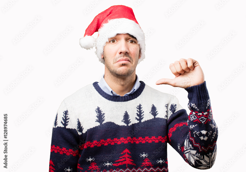 Concerned young man with a loser gesture at Christmas Concerned young man with a loser gesture at Christmas