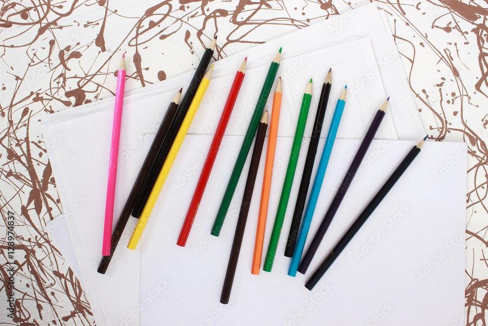 Obraz premium Colored pencils on white sheet
