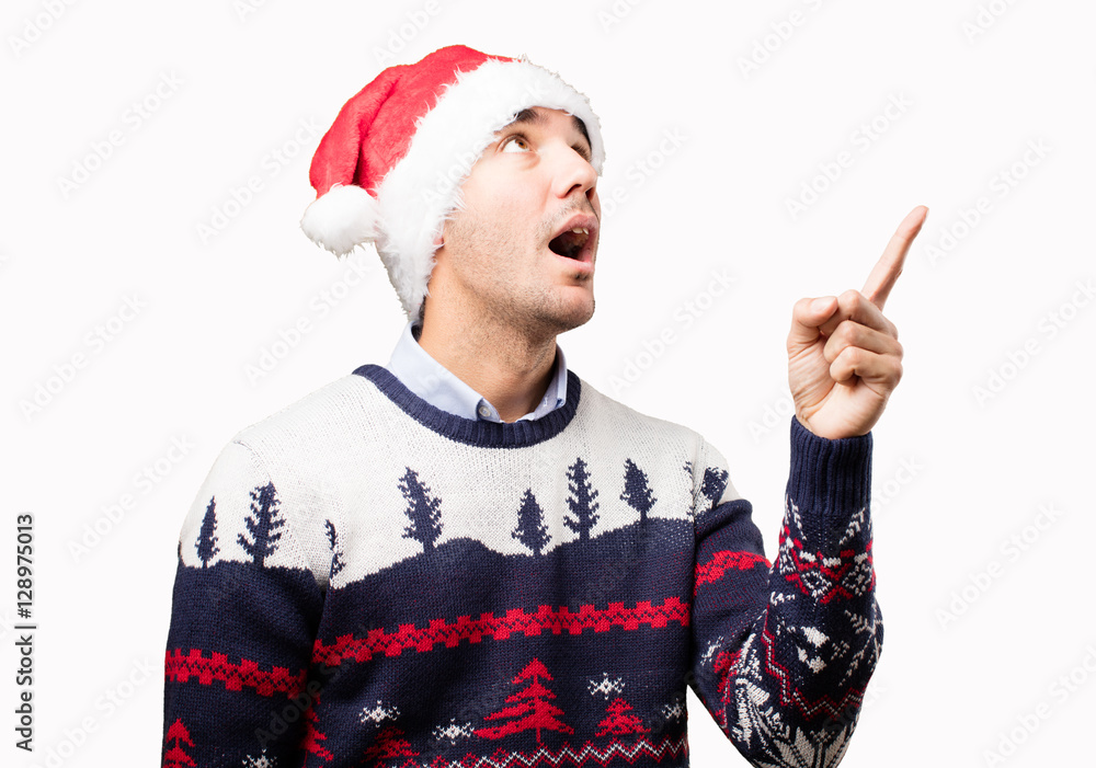 Surprised young man at Christmas pointing Surprised young man at Christmas pointing