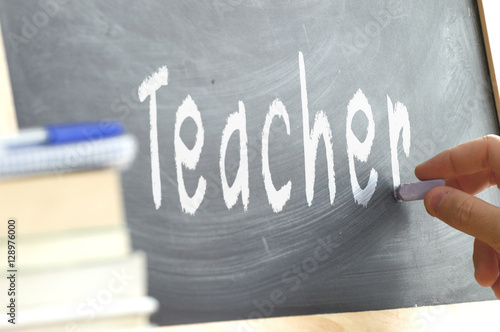 The word Teacher hand written on a blackboard. Education concept at school.