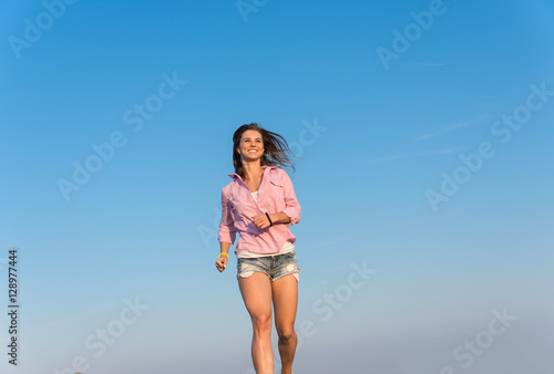 Girl runs on the camera sky background © romanets_v