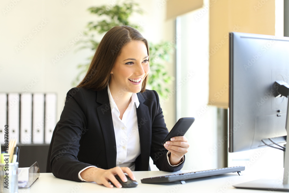 Businesswoman working with phone and computer Businesswoman working with phone and computer
