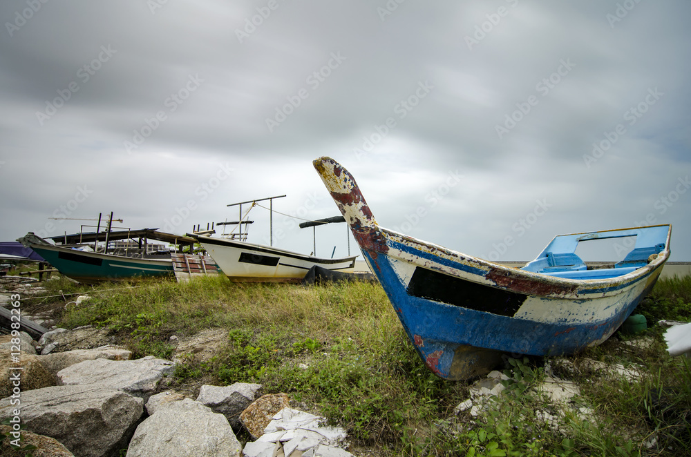 closed up fisherman boat stranded on the sandy beach and cloudy sky.color toning applied.color toning applied closed up fisherman boat stranded on the sandy beach and cloudy sky.color toning applied.color toning applied