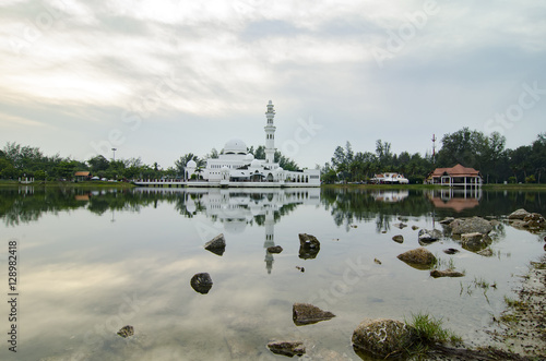 Tengku Tengah Zaharah floating mosque and lake reflection located at Kuala Terengganu, Malaysia over sunset background