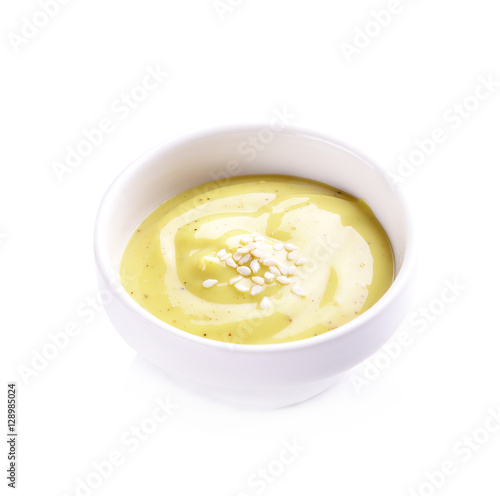Creamy sauce, salad in ceramic cup on white background