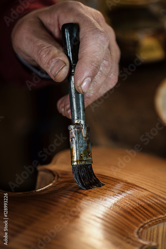 Fotografie string instruments maker varnishing violin body