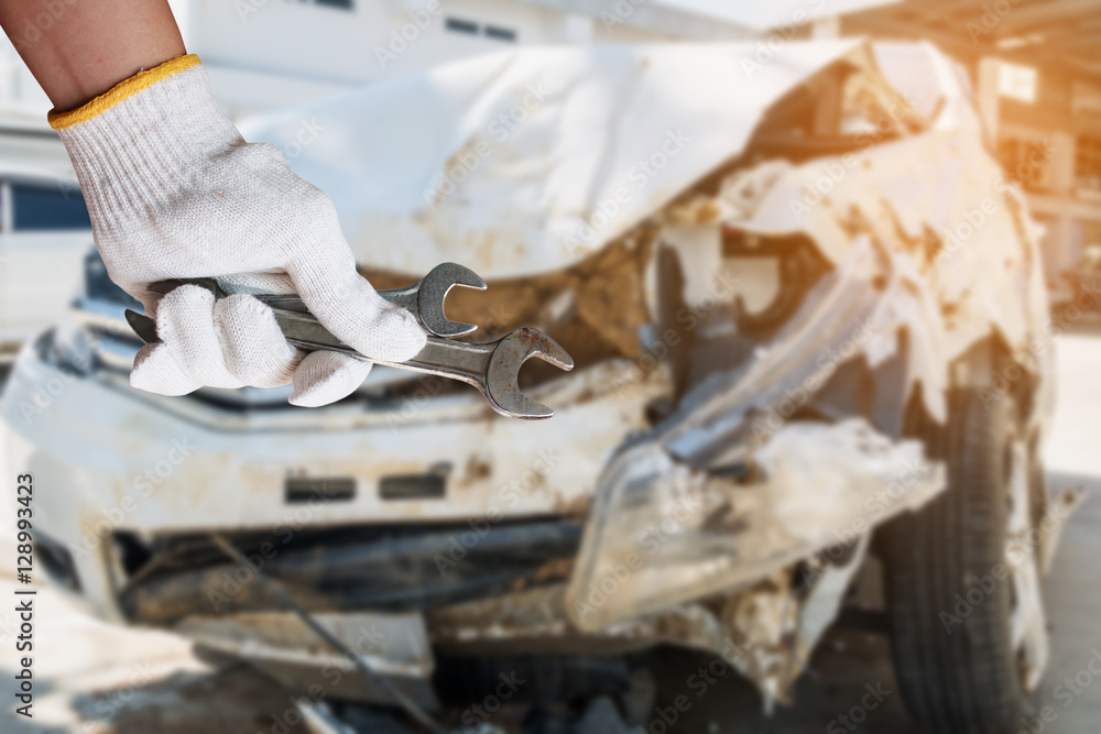 hand hold wrench with car crash damage background hand hold wrench with car crash damage background