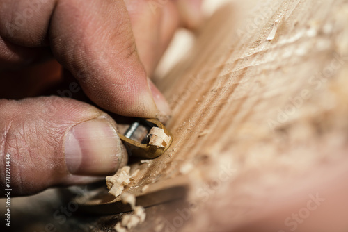lute maker carving violin body with little planer