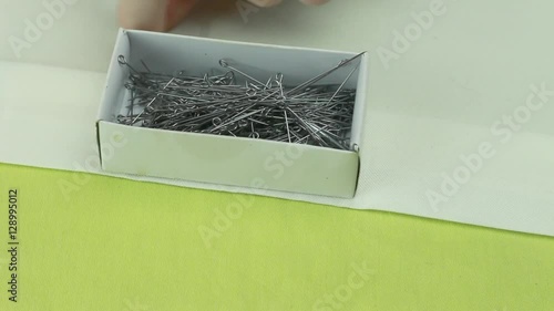Tailor Puts the Last Scattered on Beige Fabric Dressmaker Pins Into the Box and Lays a Safety Pin on the Top.