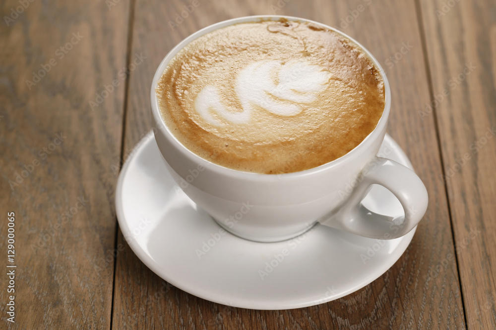 cappucciono with latte art on oak table, with shallow focus cappucciono with latte art on oak table, with shallow focus