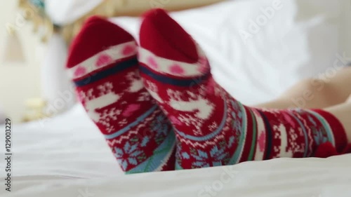 Female legs in Christmas socks in bed photo