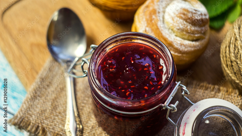 raspberry jam in a jar and muffins. selective focus, top view raspberry jam in a jar and muffins. selective focus, top view