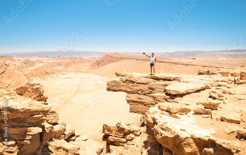 Lonely man with tattoos hiking on rock formation at 