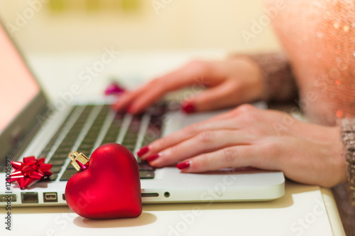 Woman typing on her laptop during Christmas.