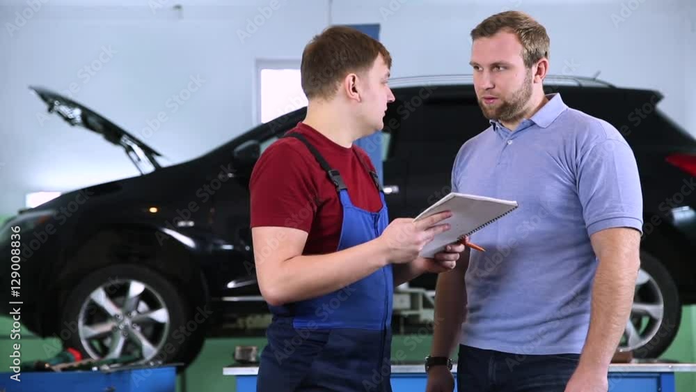 customer and mechanic discuss upcoming car repair customer and mechanic discuss upcoming car repair