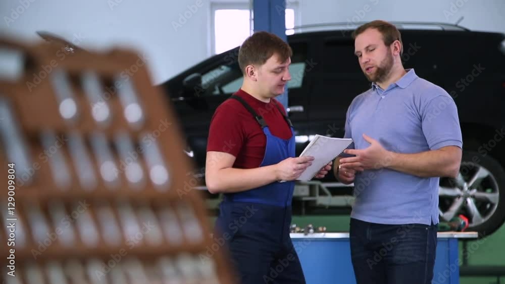 Mechanic and customer in the background of service and repair tools Mechanic and customer in the background of service and repair tools