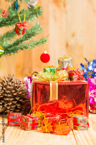 Christmas tree with gifts on wooden background.