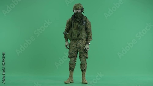 Soldier folding hands at green screen photo