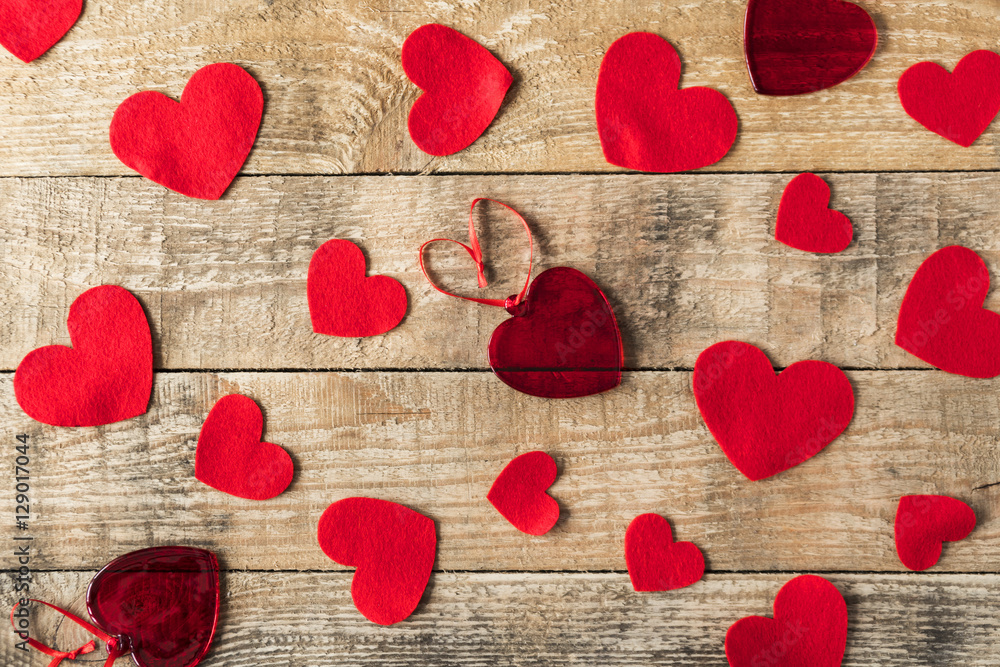 pattern of red felt, knitted and glass hearts on wooden desk pattern of red felt, knitted and glass hearts on wooden desk