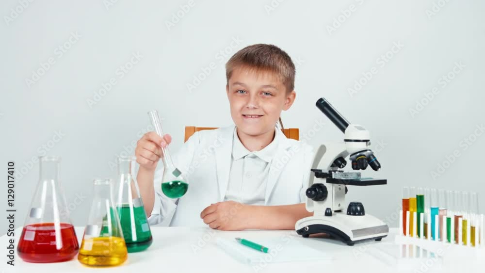 Portrait chemist conducting experiments. Schoolboy holding chemical flask and looking at camera Portrait chemist conducting experiments. Schoolboy holding chemical flask and looking at camera