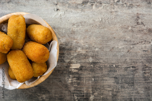 Traditional fried Spanish croquetas (croquettes)  in plate on wooden background
 photo