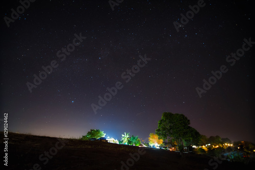 Starry night over tribe village on mountain.