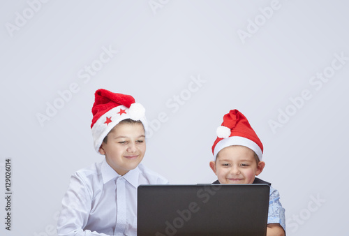 On a gray background the boys looking at a laptop