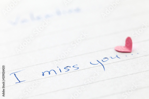 Handwritten phrase "I miss you" with heart. Shallow depth of field.
