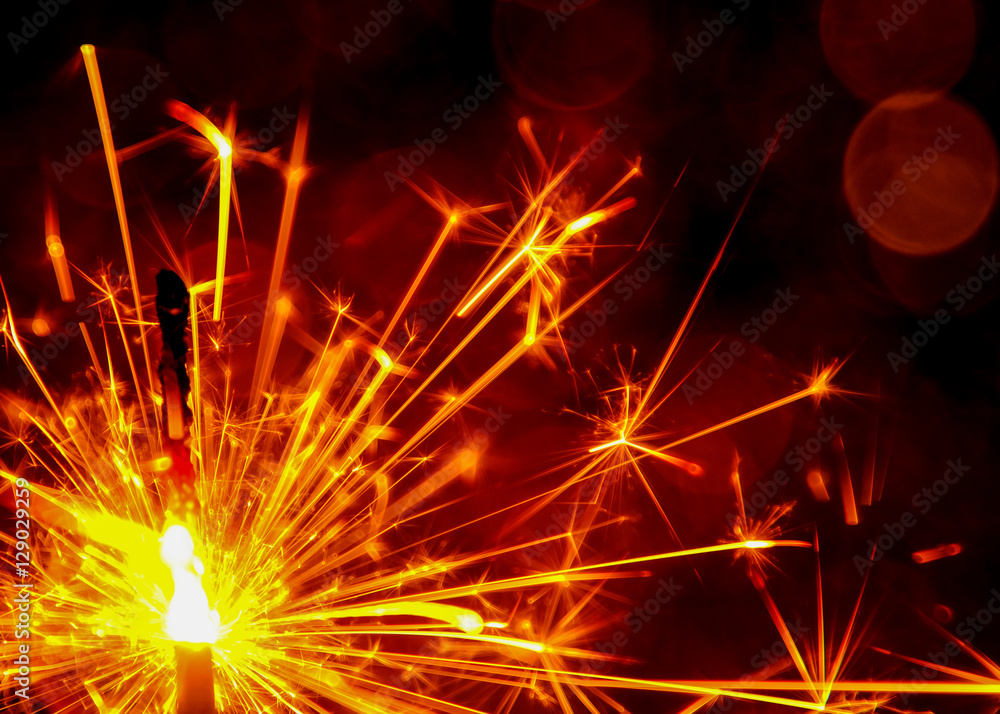 Christmas and New Year party sparkler with abstract circular bokeh background Christmas lights. Christmas and New Year party sparkler with abstract circular bokeh background Christmas lights.