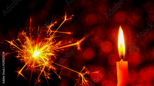 Christmas and New Year party sparkler and Candle flame light at night with abstract circular bokeh background Christmas lights.